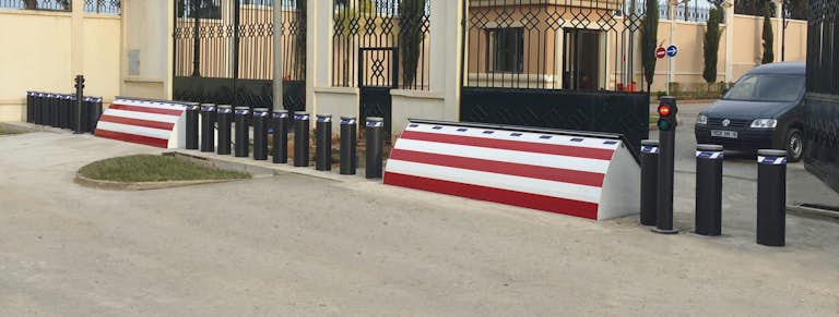 Vit-röda säkerhetshinder på insidan av grindarna till en fastighet.