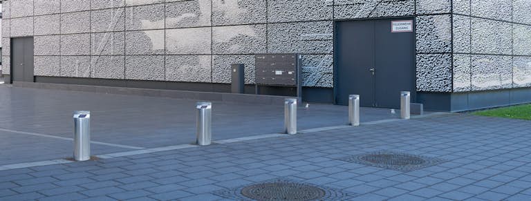 Område bredvid en fastighet med 5 upphöjda pollare i silver.