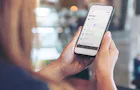 Full säkerhet – när och var som helst Kvinna sitter med en smartphone i handen.