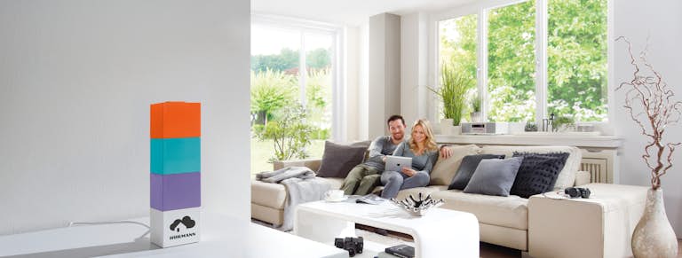 Man och kvinna sitter i soffan med en ipad i handen.