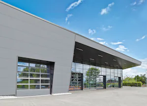Det gäller i lika stor utsträckning för kvalitet,... Grå industrifastighet med glasad insustriport och glaspartier.