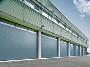 Sectional doors open vertically, creating free space in... Sectional doors open vertically, creating free space in front of and behind the door. The door sections are stored flat underneath the ceiling, vertically above the opening or along the roof. Series...