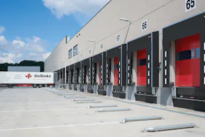 Distribution | Transportation
In distribution and... Loading dock area with several docks that have red commercial doors and dock shelters