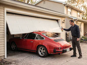 A squeaking garage door is a good example of why specialized... a man lubricates a garage door that is damaged
